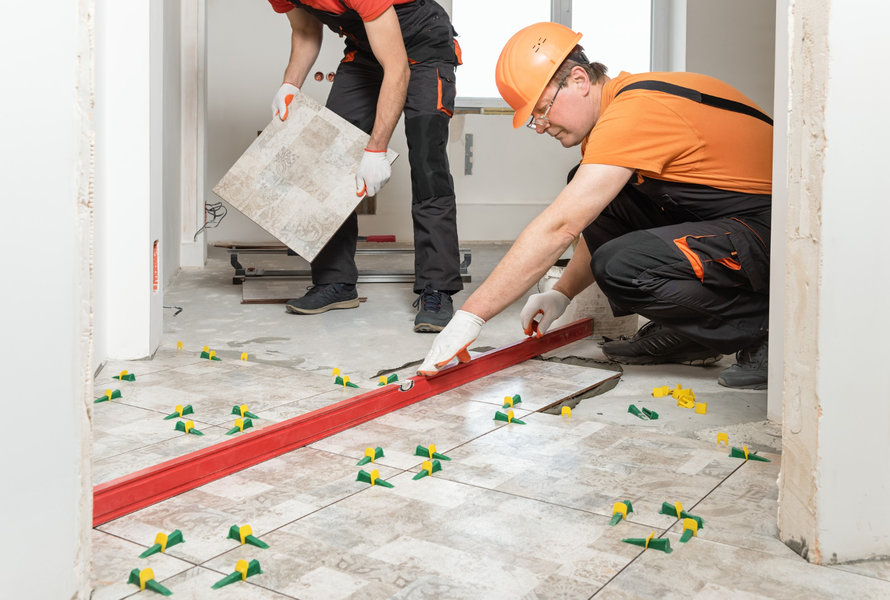 Homens durante assentamento de piso em casa