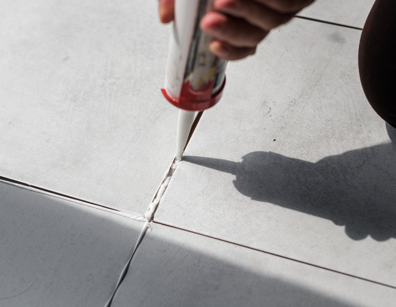 Homem prepara colocação da lajota no chão