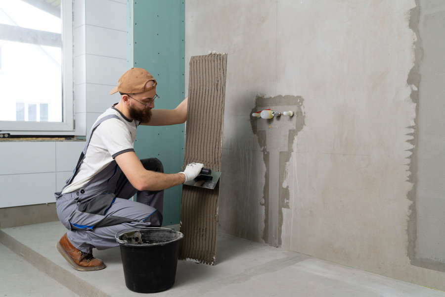 Profissional colocando revestimento no banheiro