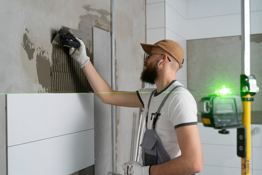 Profissional encaixando azulejo no revestimento da parede