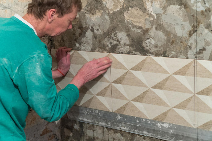 Profissional prepara área para colocar a cerâmica na parede Profissional prepara área para colocar a cerâmica na parede