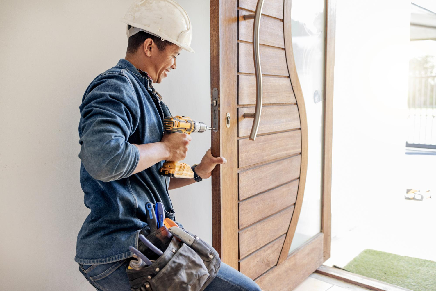 Homem concluindo a instalação de porta na casa. Imagem: Freepik Instalação de portas: passo a passo com a UNIHANDS. Imagem: Freepik