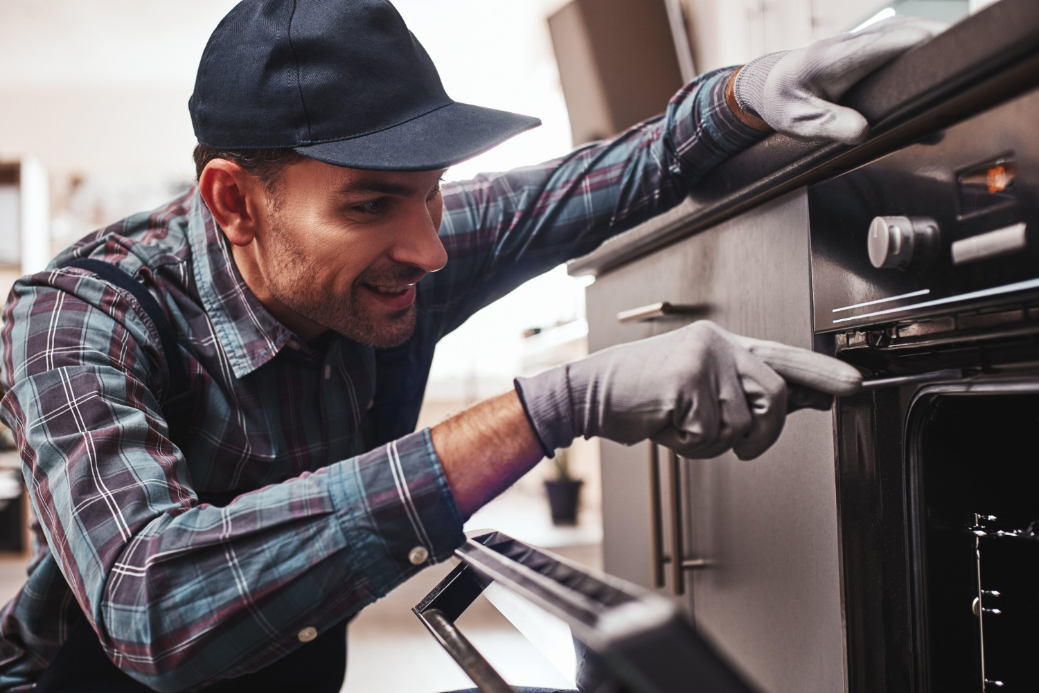 Homem faz manutenção de fogão e observa os ajustes. Imagem: Freepik