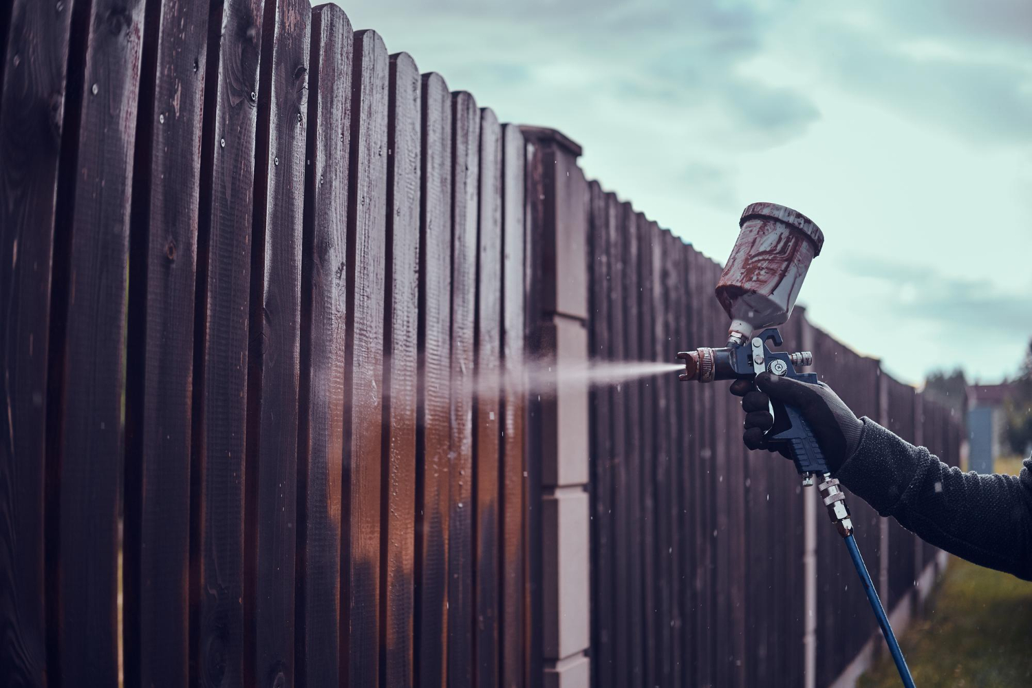 profissional durante processo de pintura de portão enferrujado