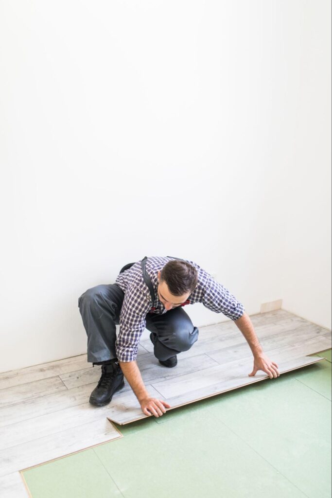 Homem colando piso no chão